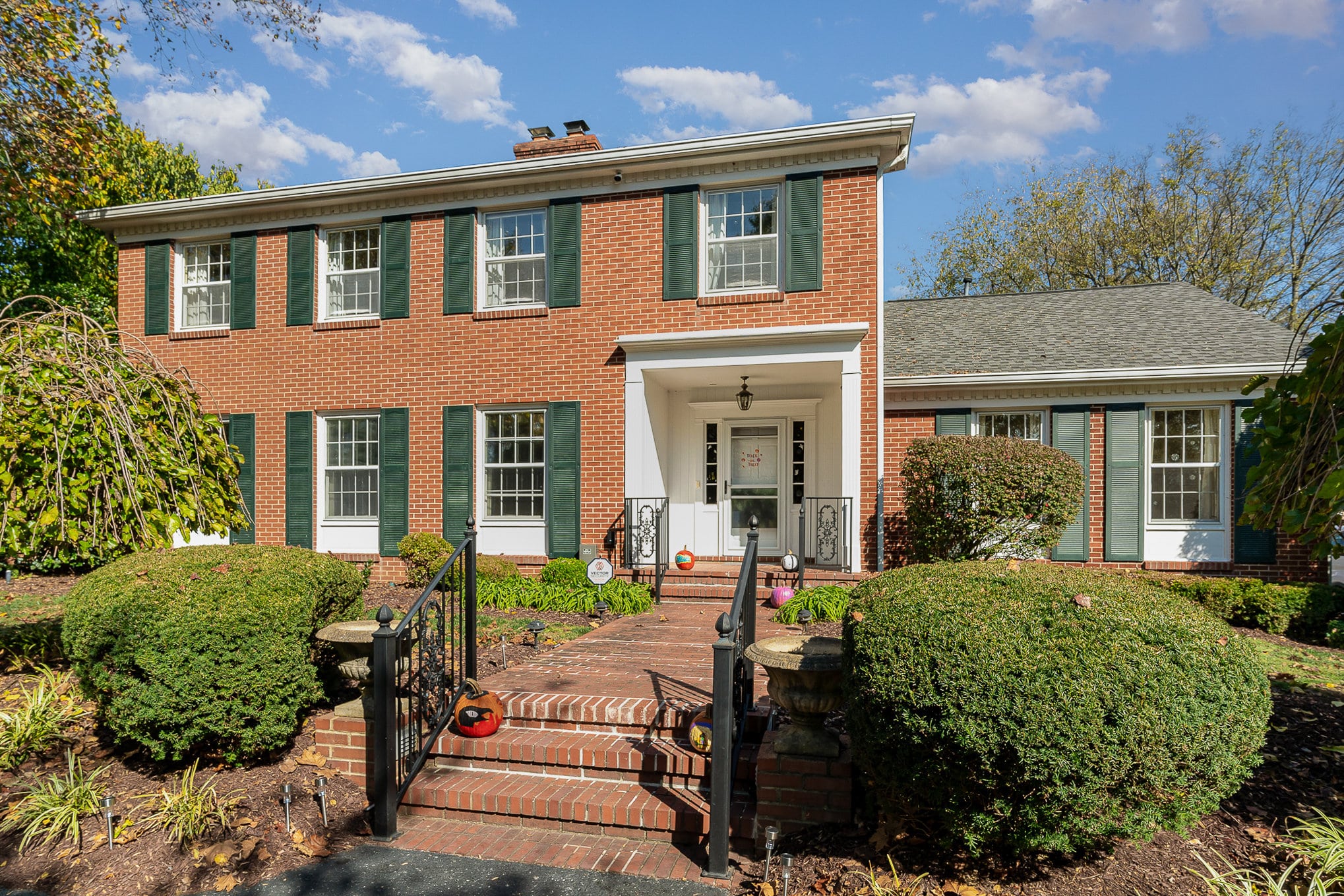 005_file_306 | Nashville Mental Health Brick home exterior with green shutters, a well-maintained lawn, and a welcoming front entrance. Real estate photography.