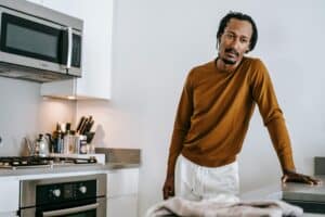 man standing in kitchen thinking