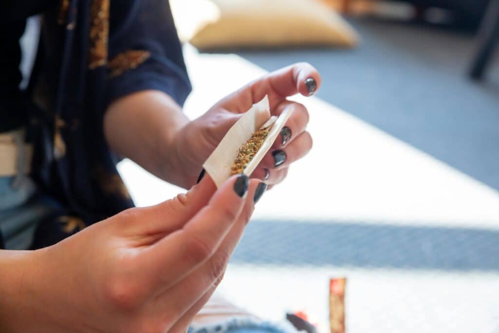 person rolling up weed to smoke