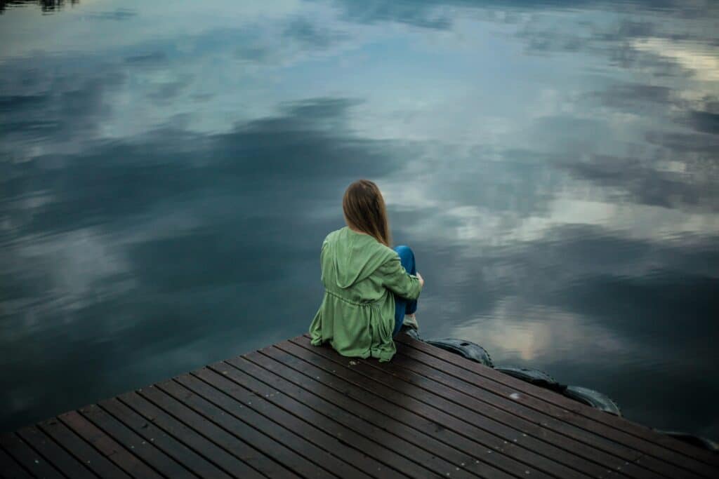 person looking over the water on a dock