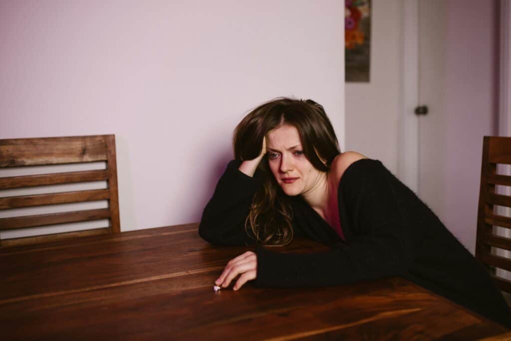 woman sitting table thinking