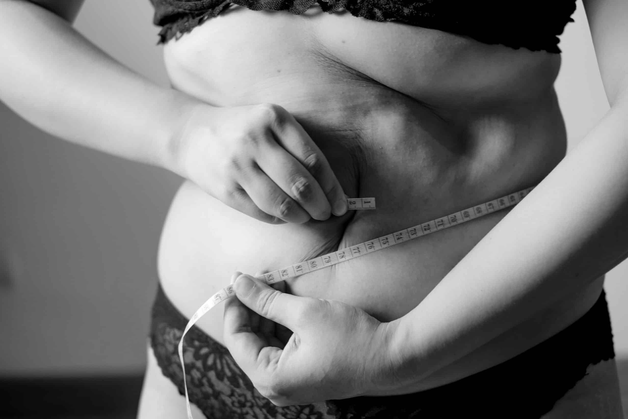 person measuring her stomach