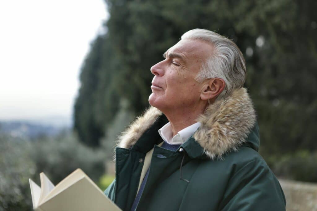 man taking a big breath while reading outside