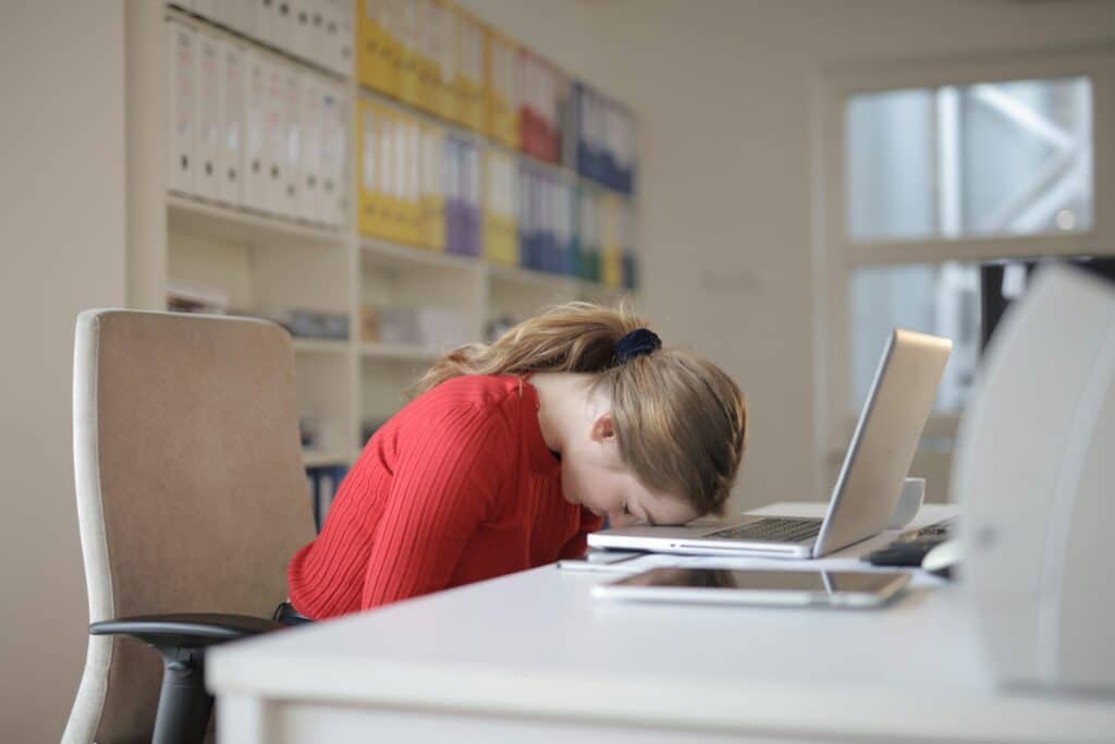 person with head on her laptop