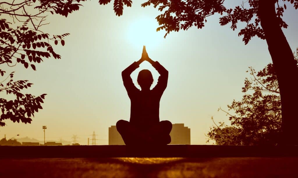 person doing yoga in the sunset