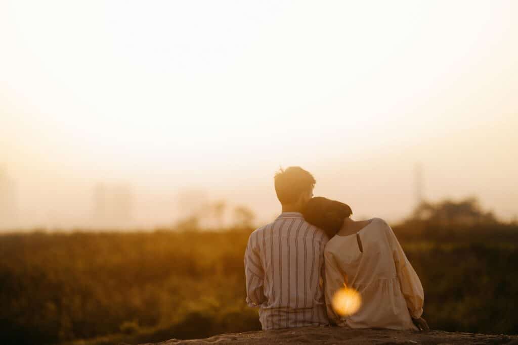 two people outside enjoying a sunset