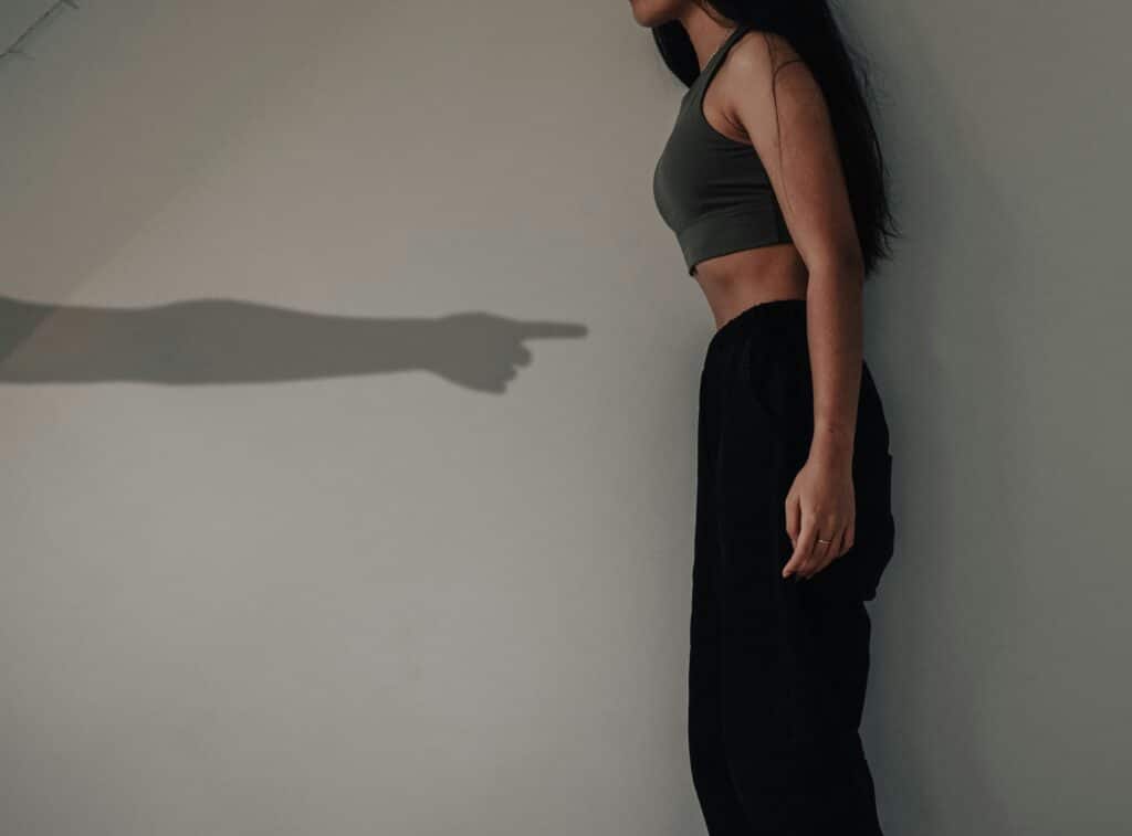 person in shadow pointing at human