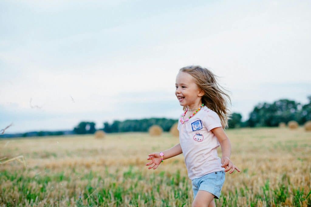 young girl smiling and running