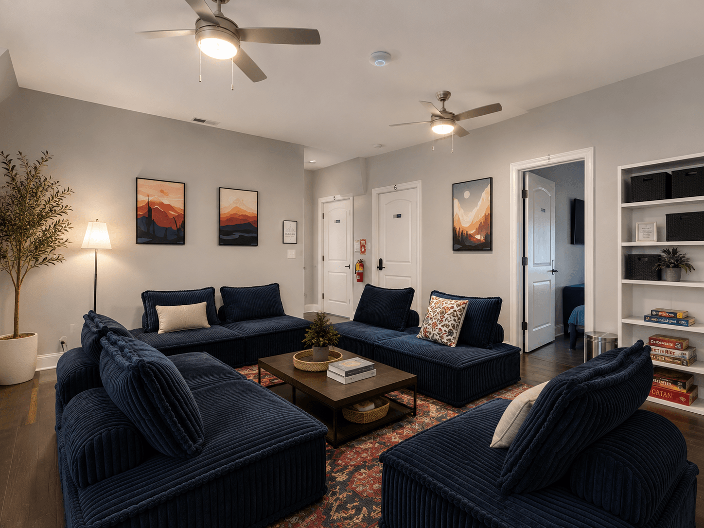 Cozy living room with a navy corduroy sectional arranged in a U-shape around a wooden coffee table and a patterned rug.