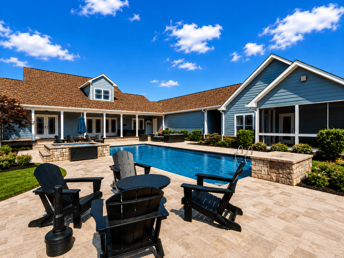Resort pool area with blue buildings, stone lounge bar, and black Adirondack chairs on beige pavers under a bright sky.
